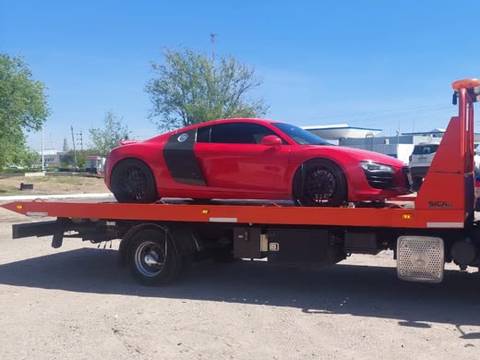 Auto deportivo rojo sobre la plataforma de una grúa