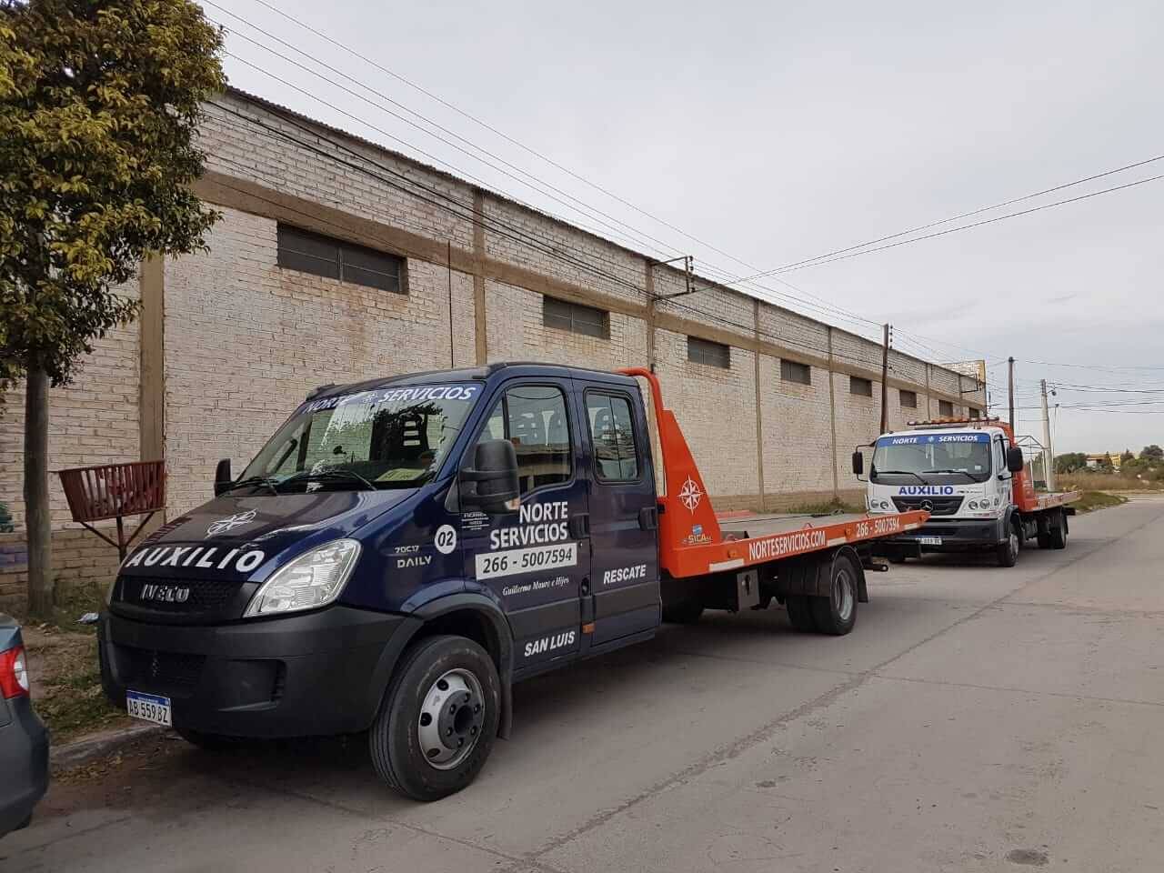 Dos grúas de la flota estacionadas: una azul de rescate y una blanca de auxilio