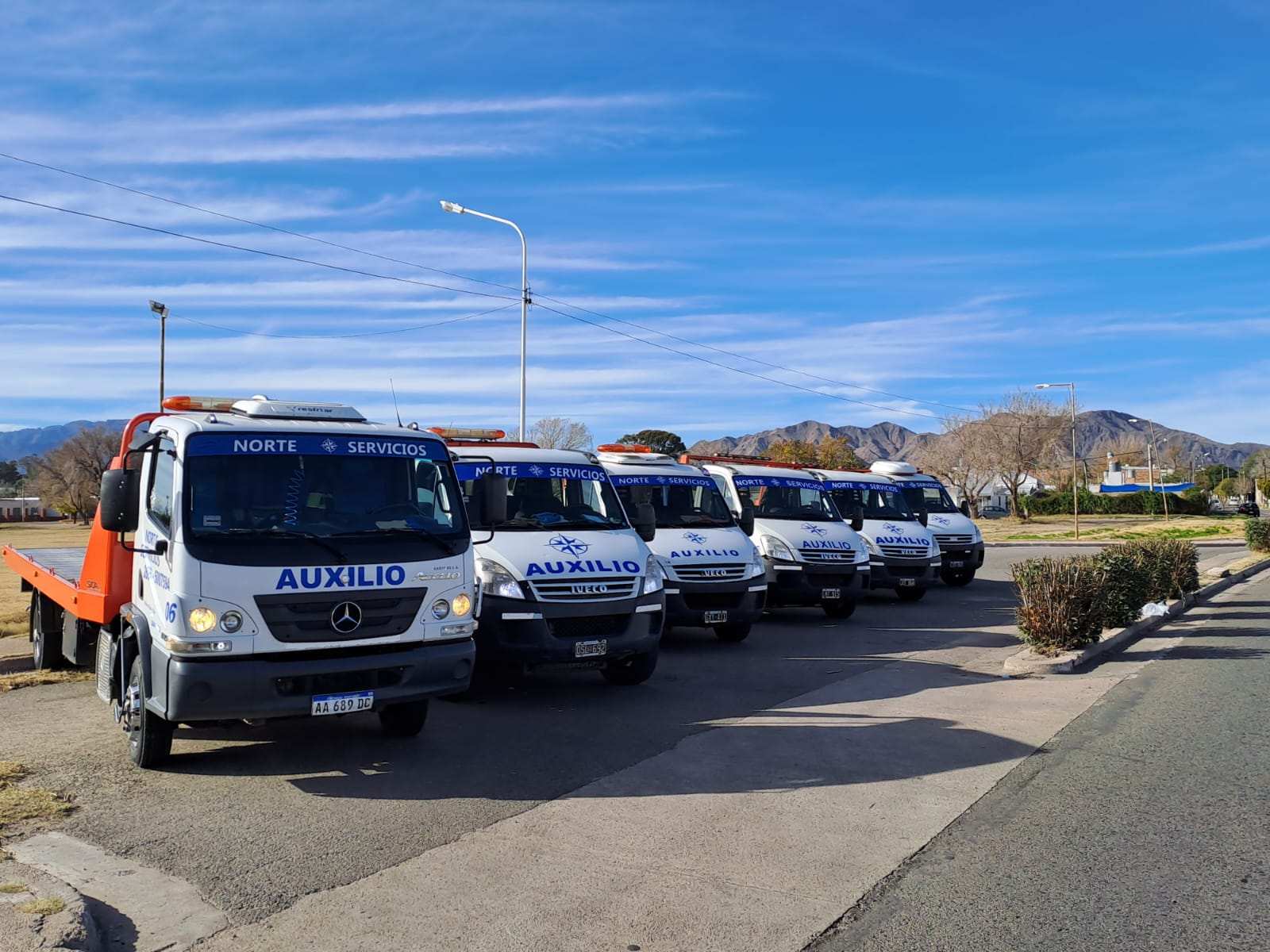 Flota de grúas de plataforma de Grúas Norte San Luis alineada en la calle, con las sierras de San Luis de fondo