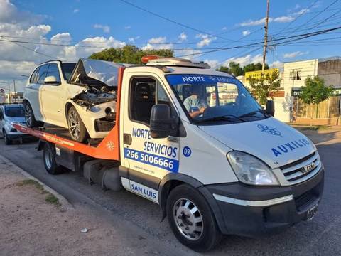 Camioneta blanca chocada de frente, cargada en una grúa de la flota