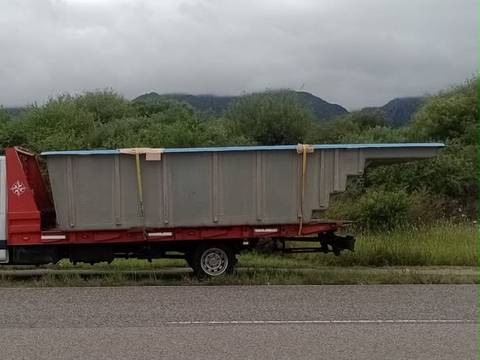 Pileta de fibra cargada en una grúa, en la ruta con las sierras de fondo